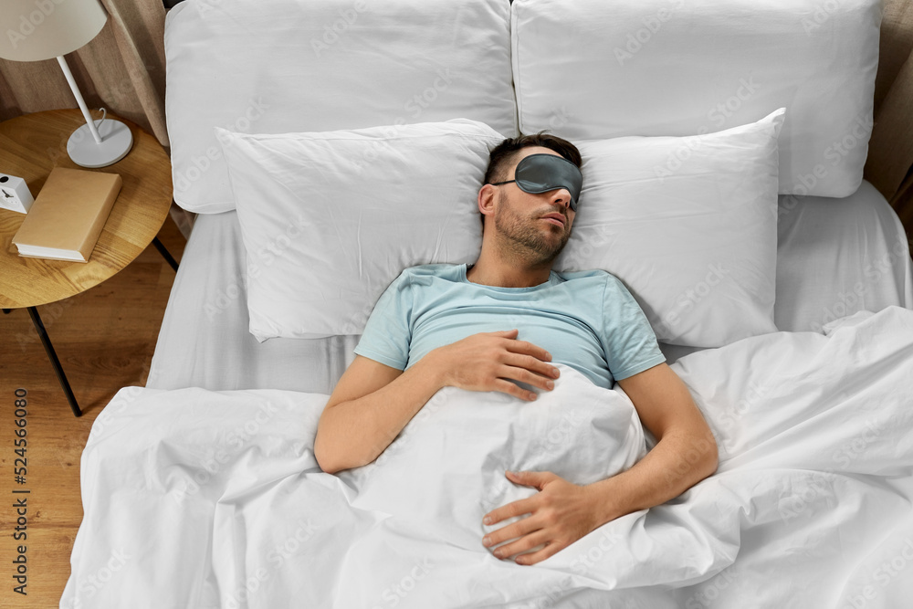 мужчина спит в кровати. пропуск тренировки ухудшает сон.adobe.stock.com